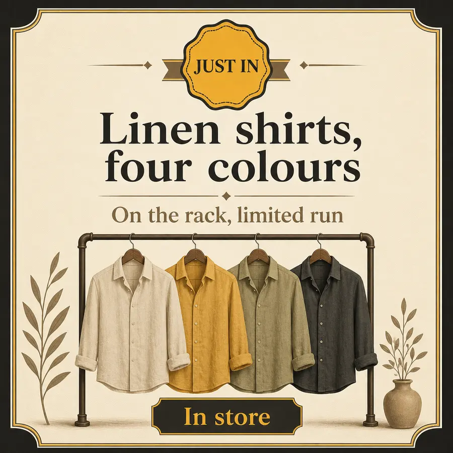 A folded stack of linen shirts in four different colors on a boutique table